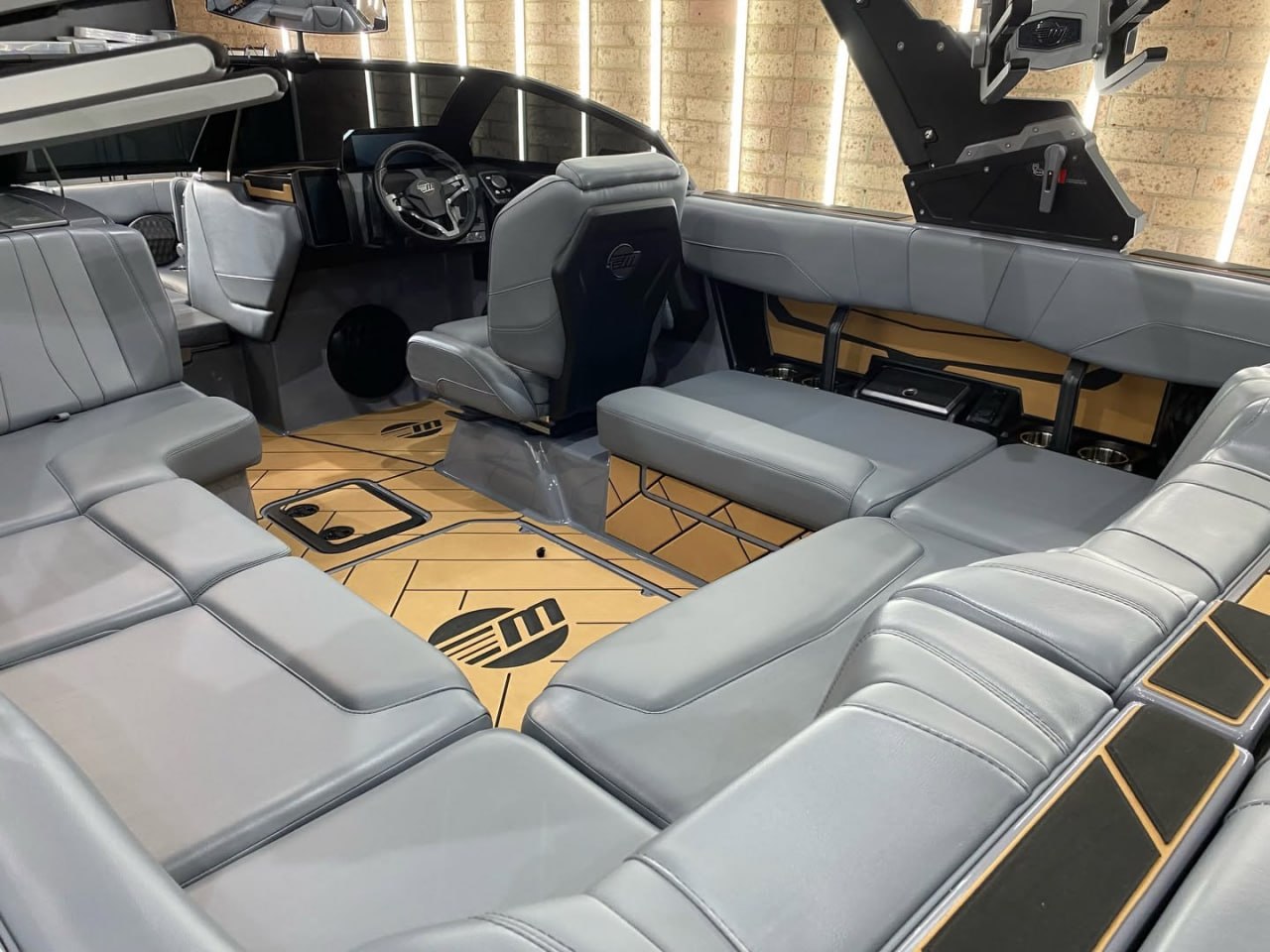 Custom wakeboat interior, gray and tan upholstery with branded flooring, detailed by CCTD